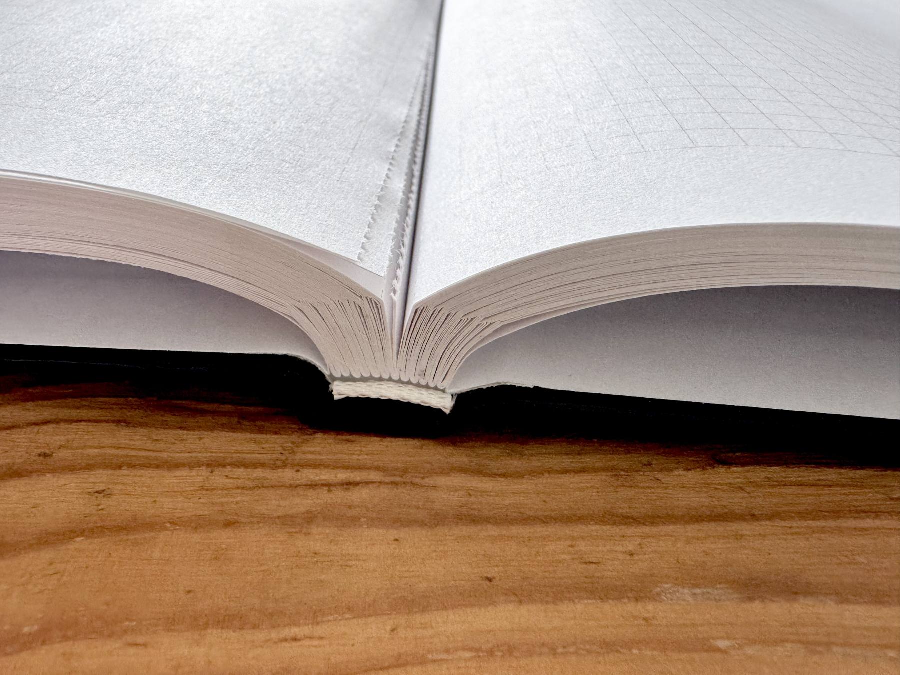 Fadengeheftete Bindung eines Hardcover-Notizbuchs im Detail Fadengeheftete Bindung eines Hardcover-Notizbuchs im Detail